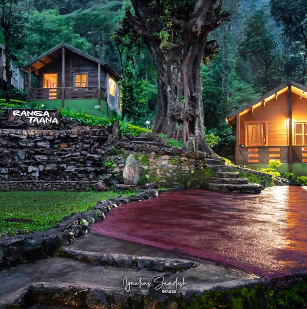 A cozy cottage nestled in the picturesque village of Ranga Taana, surrounded by lush greenery and blooming flowers.