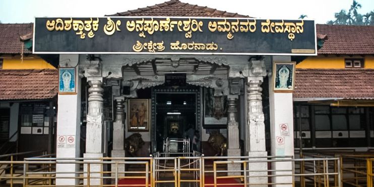 The entrance to Horanadu Annapoorneshwari Temple, surrounded by lush greenery, offers a serene spiritual retreat in India.