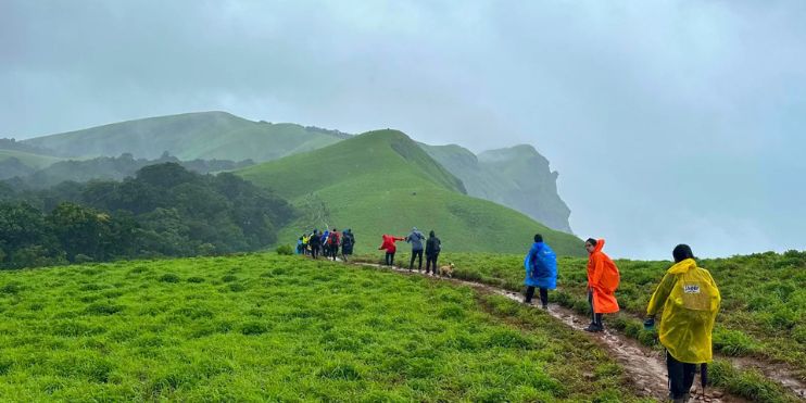 A group of people walking on a trail in the rain.