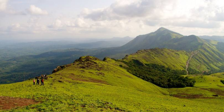 A group of hikers walking on the summit of Mullayanagiri Peak.