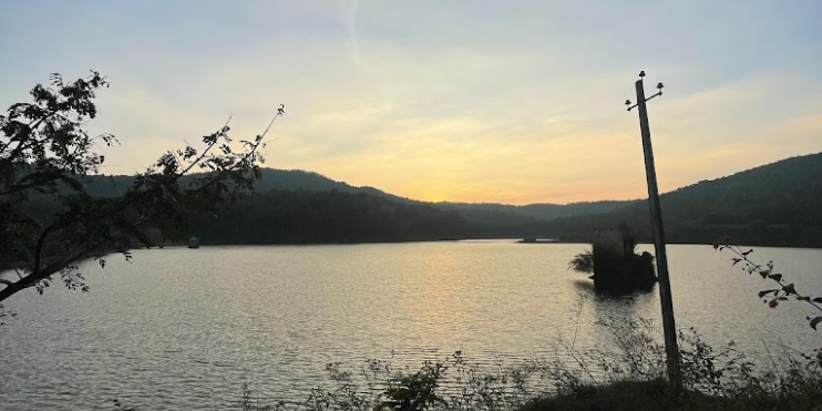 Scenic sunset over Hirekolale Lake, reflecting vibrant colors on the tranquil water surface.