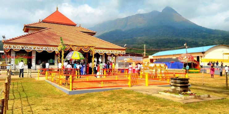  A small temple surrounded by visitors, showcasing its serene architecture and inviting atmosphere in Karnataka.