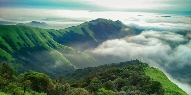 Aerial view of Kodachadri Hill showcasing majestic mountains and clouds scattered across the sky.