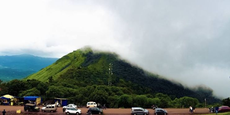 Cars parked atop Mullayanagiri Peak, the highest point in Karnataka, offering breathtaking views of the Western Ghats.