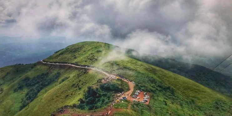 A scenic mountain road leading to Mullayanagiri, the highest peak in Karnataka, offering panoramic views and a spiritual temple at the summit.