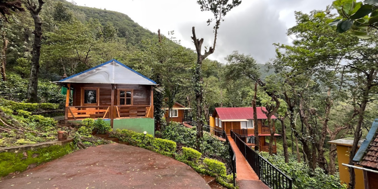 A quaint cabin nestled in the woods, featuring a charming walkway leading to its entrance, surrounded by nature.