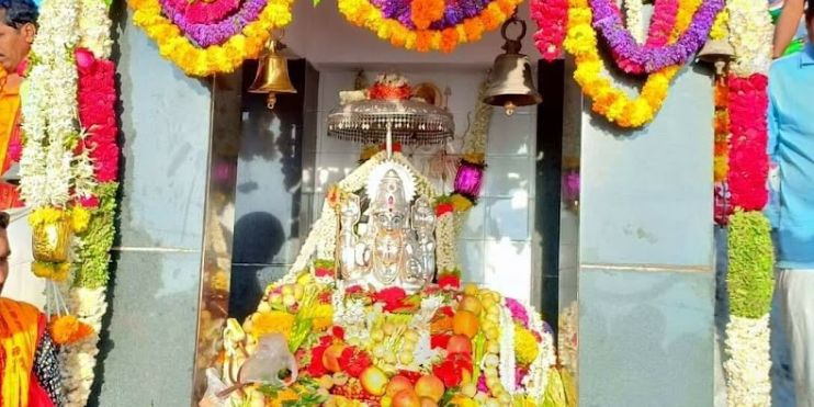 A serene shrine adorned with vibrant flowers and a statue of Goddess Deviramma, symbolizing devotion and spiritual tranquility.