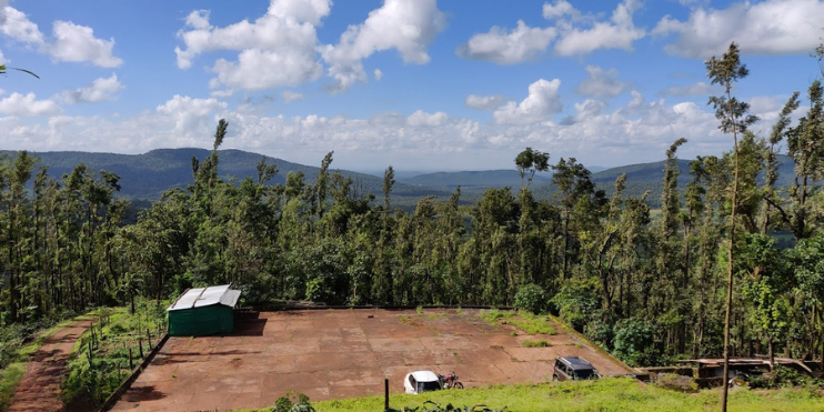 A scenic view of majestic mountains from a hillside, showcasing the natural beauty of the Western Ghats in Chikmagalur.