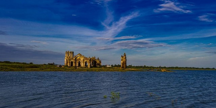 A large church ruins on an island, surrounded by a serene lake, perfect for stunning photography and social media posts.