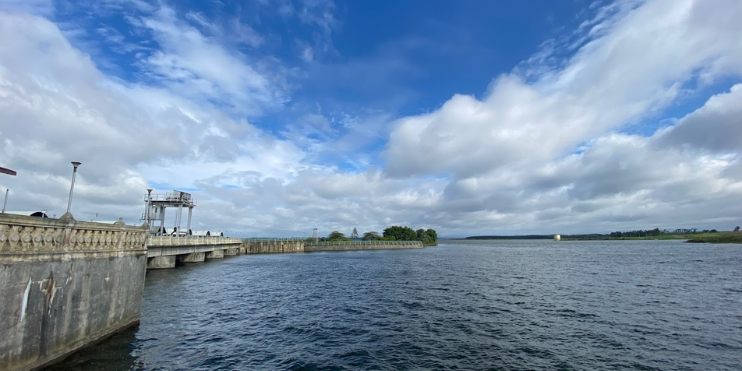 The Yagachi Dam features a vast reservoir, a bridge, and surrounding greenery, highlighting its serene natural beauty.