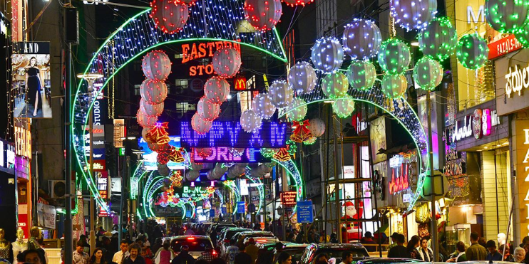 A crowded street in Chikmagalur, vibrant with people and cars, capturing the essence of Christmas festivities.