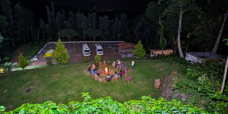 People congregate around a fire at night, partaking in festive activities at Ranga Taana Resort. 