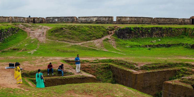 People standing atop a hill beside a wall, gazing at the landscape, embodying a sense of adventure and exploration.