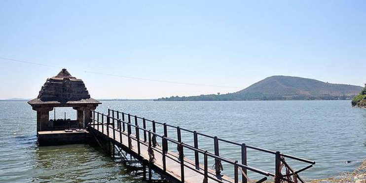 A serene pier with a small building, surrounded by the tranquil waters of a lake, ideal for relaxation and adventure.