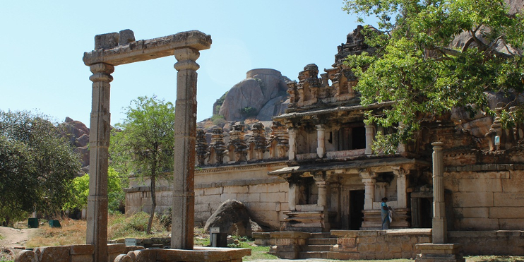 A large stone building showcasing intricate carvings, embodying the spiritual heritage of Karnataka's temples.