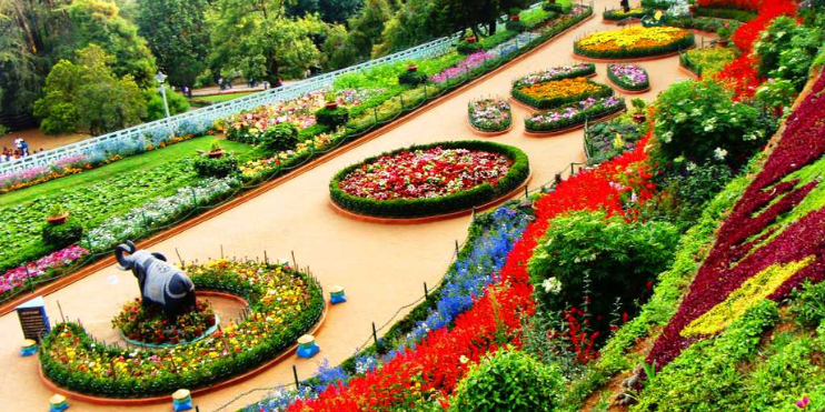 A vibrant flower garden featuring a large circular flower bed, surrounded by lush greenery and scenic beauty.