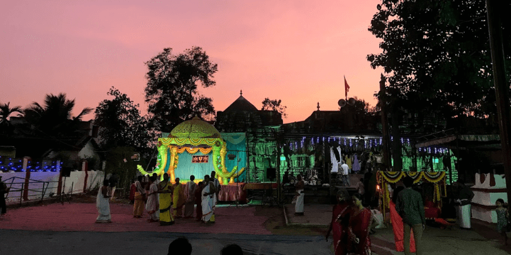 People gather around the Lakshmi Narasimha Swamy Temple at sunset, highlighting its architectural beauty and spiritual significance.
