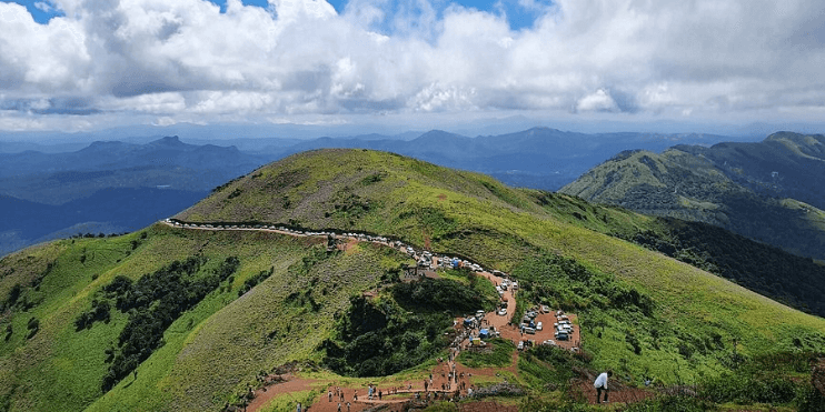 Panoramic view from Mullayanagiri, Karnataka's tallest peak, showcasing lush landscapes and winding trails.