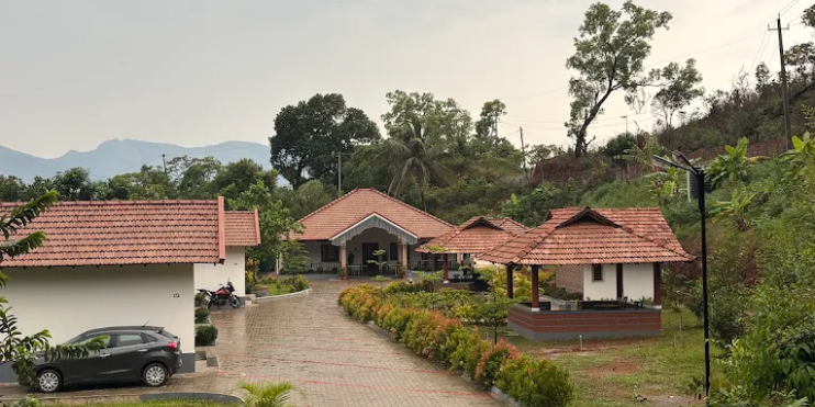A house with a driveway and a parked car, set in a serene environment, ideal for a peaceful retreat in Kemmangundi.